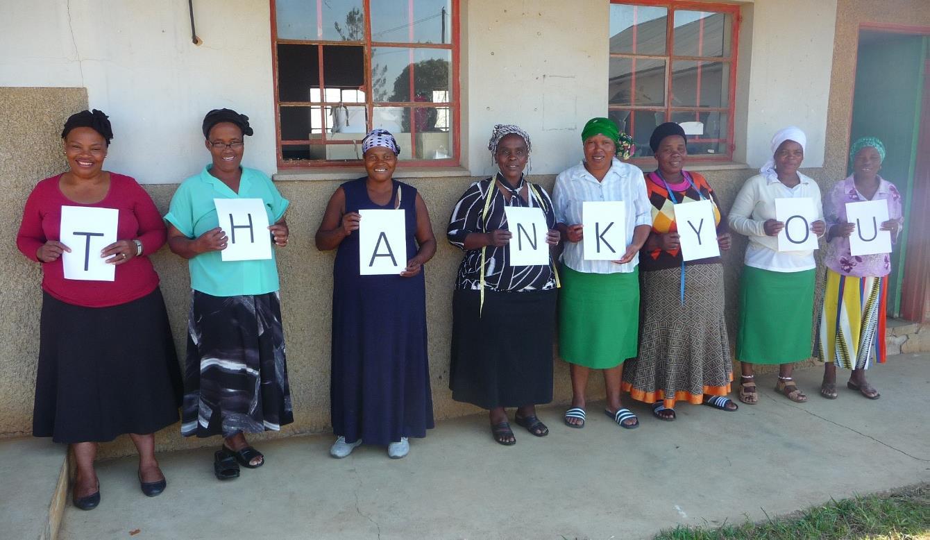 Afrikaanse vrouwen die samen de letters T-H-A-N-K-Y-O-U vasthouden